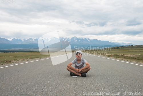 Image of Young boy sitting on the road