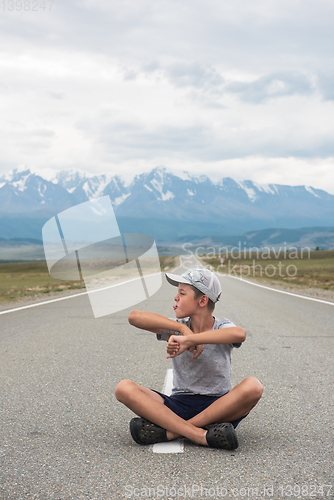 Image of Young boy sitting on the road