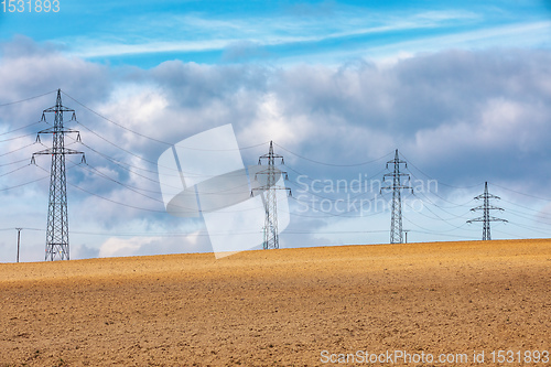 Image of high voltage power lines against a blue sky