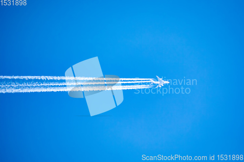 Image of long trail of jet plane on blue sky