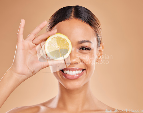 Image of Skincare, lemon and face of woman with smile in studio for wellness, facial treatment and natural cosmetics. Beauty, dermatology spa and happy girl with citrus fruit for detox, vitamin c and health