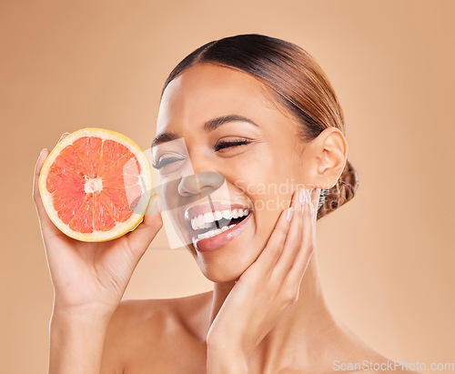 Image of Skincare, grapefruit and face of woman with smile in studio for wellness, facial treatment and natural cosmetics. Beauty, spa aesthetic and happy girl with fruit for detox, vitamin c and healthy skin