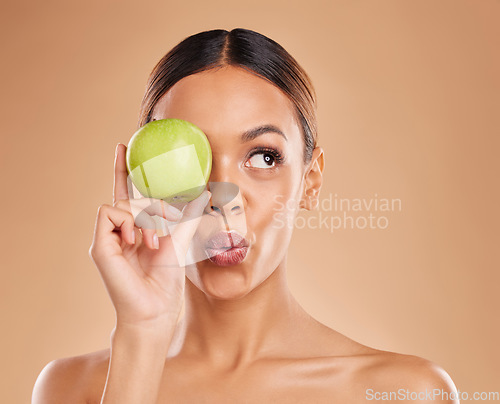 Image of Beauty, skincare or woman with apple in studio on beige background for healthy nutrition or clean diet. Eye, hand or girl model advertising or marketing natural fruits for nutrition or wellness