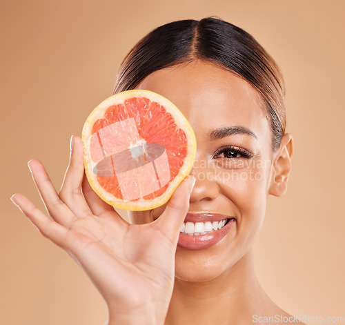 Image of Skincare, grapefruit and portrait of woman with smile in studio for wellness, facial treatment and natural cosmetics. Beauty, spa and happy girl with fruit slice for detox, vitamin c and dermatology