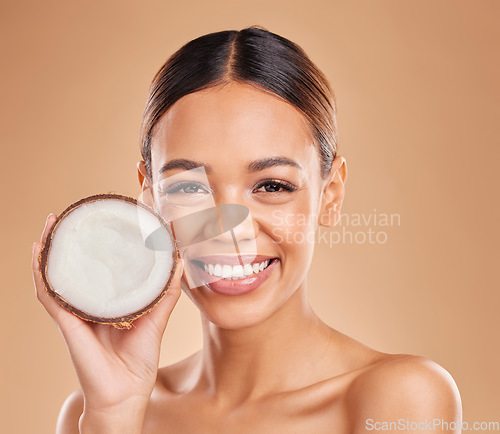Image of Skincare, coconut and portrait of woman with smile for wellness, facial treatment and natural cosmetics. Beauty, dermatology spa and happy girl with fruit for detox, organic and nutrients in studio