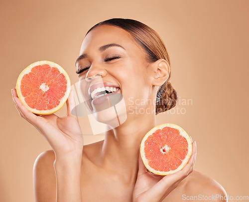 Image of Skincare, grapefruit and face of woman with laugh in studio for wellness, facial treatment and natural cosmetics. Beauty, spa aesthetic and happy girl with fruit for detox, vitamin c and dermatology