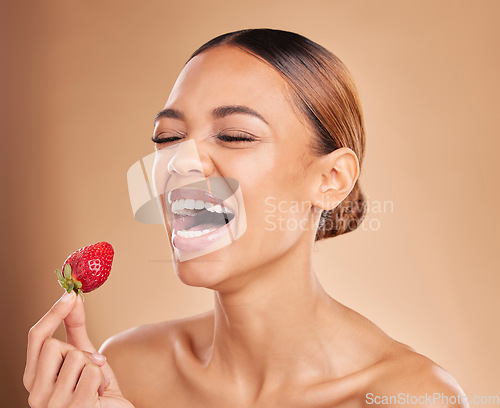 Image of Beauty, skincare or funny woman with strawberry in studio on beige background for healthy nutrition or clean diet. Smile, happy or girl model laughing with natural fruits for nutrition or wellness