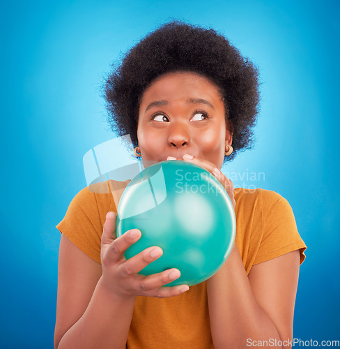 Image of Balloon, happy and black woman in studio for celebration, good news or birthday on blue background. Party, blowing and girl with inflatable while celebrating, excited and having fun while isolated