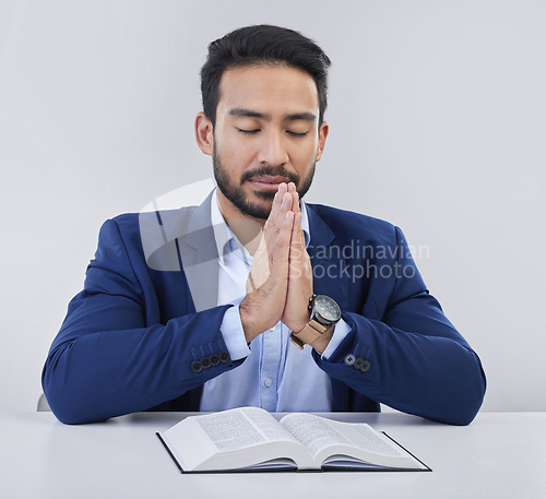 Image of Mockup, faith and Asian man, praying, bible and guidance against grey studio background. Japanese male, believer and Christian guy with holy book, prayer and hope for solution, religious or gratitude