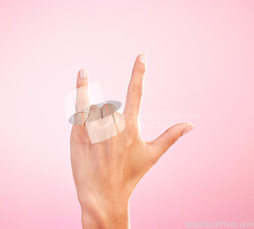 Image of Sign language, funky and hand with a gesture for rock isolated on a pink background in a studio. Celebrate, deaf communication and person gesturing for metal music, emoji and expression on a backdrop