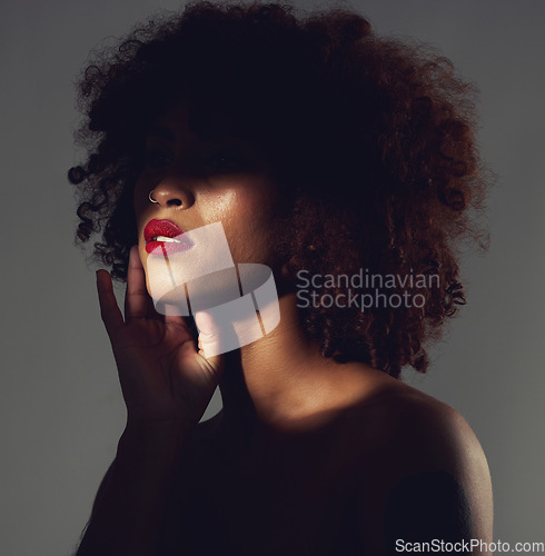 Image of Makeup, red lipstick and shadow of black woman with beauty, afro or natural hair in studio. Face of aesthetic female model with a skin glow, shine and color on lips for art, power and facial skincare