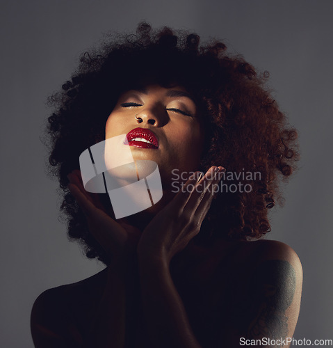 Image of Black woman, shadow and makeup or red lipstick with beauty, afro or natural hair in studio. Face of aesthetic female model with hands to show skin glow, shine and color on lips for art and skincare