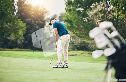 Image of Man, golf ball and putter on grass to ready for game, sport and aim shot in competition with focus outdoor. Professional golfer, start and put shooting for contest on field, lawn and course in summer