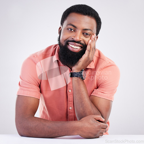 Image of Happy, handsome and portrait of a black man leaning on a table isolated on a white background. Smile, relax and an African guy looking relaxed, calm and at peace with confidence on a studio backdrop