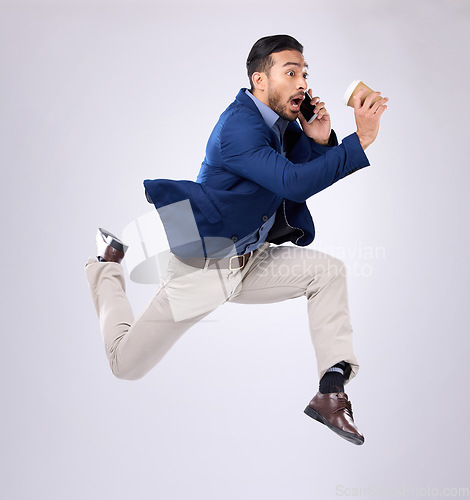 Image of Phone call, rush and late with a business man on white background in studio running to an appointment. Conversation, coffee and hurry with a male employee sprinting fast to keep a schedule