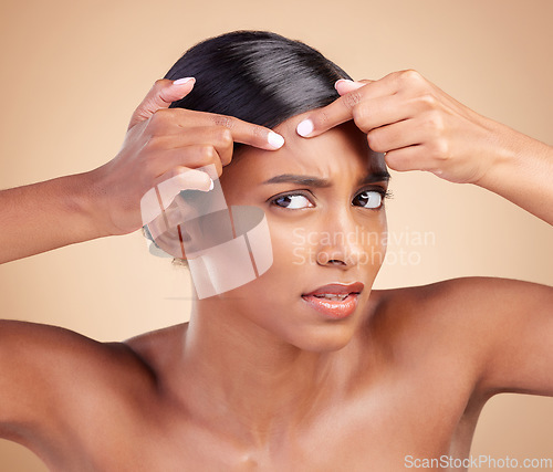 Image of Indian woman, pimple and skincare in studio with face, cosmetics and stress by background. Model girl, young asian and hand on forehead for cosmetic wellness with worry, skin acne or facial aesthetic