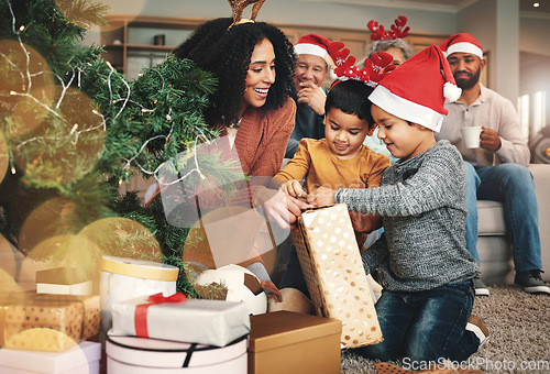 Image of Christmas, family and boys opening a gift, celebrating a holiday and happy with a box. Smile, giving and excited children starting to open a present from their mother during festive season together