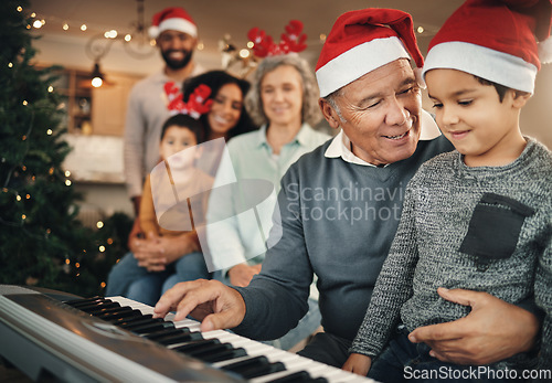 Image of Family, christmas and grandfather with grandchild on piano for learning, teaching and bond in their home. Music, instrument and retired pianist performing for kids and parents in festive celebration