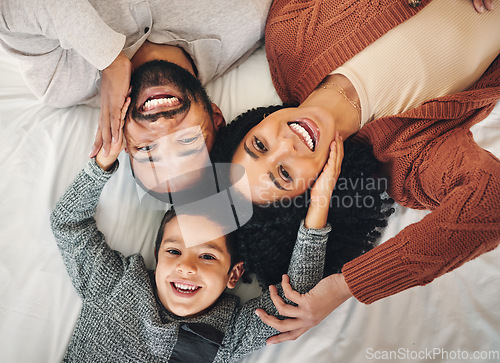 Image of Family, laughing and top view portrait on bed in bedroom, bonding and care in home. Love, smile and happy mother, comic father and funny boy child playing, having fun and enjoying joke time together.