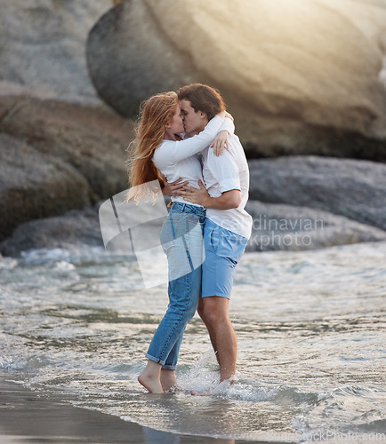 Image of Love, kiss and happy with couple at beach for romance, relax and vacation trip. Travel, sweet and cute relationship with man and woman kissing on date for summer break, affectionate and bonding