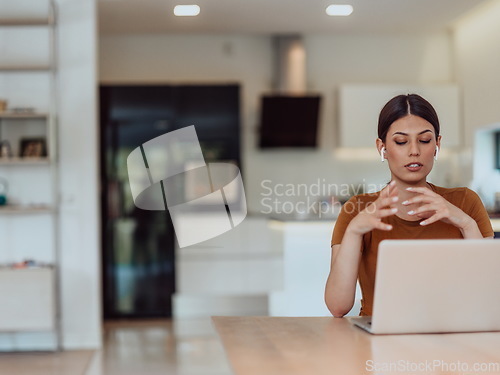 Image of Woman sitting in living room using laptop look at cam talk by video call with business friend relatives, head shot. Job interview answering questions.