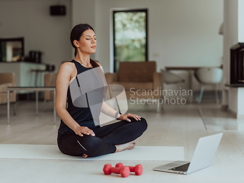 Image of Young Beautiful Female Exercising, Stretching and Practising Yoga with Trainer via Video Call Conference in Bright Sunny House. Healthy Lifestyle, Wellbeing and Mindfulness Concept.