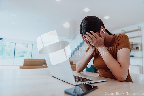 Image of Disappointed woman sitting in living room using laptop. Business concept