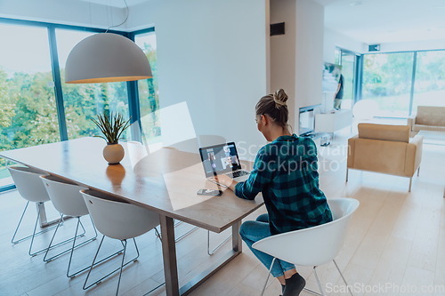 Image of Woman sitting in living room using laptop look at cam talk by video call with business friend relatives, head shot. Job interview answering questions.