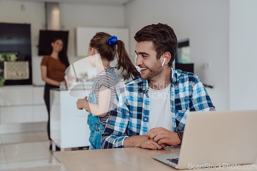 Image of Father and daughter in modern house talking together on laptop with their family during holidays. The life of a modern family