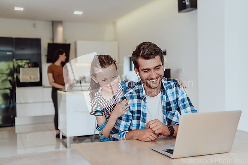 Image of Father and daughter in modern house talking together on laptop with their family during holidays. The life of a modern family