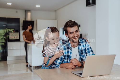 Image of Father and daughter in modern house talking together on laptop with their family during holidays. The life of a modern family