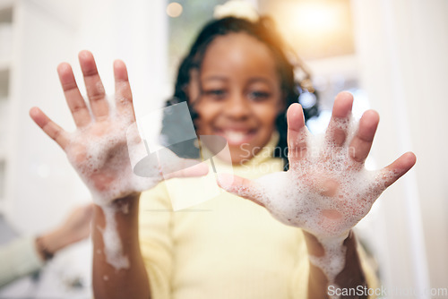 Image of Washing hands, girl and portrait with soap foam in a bathroom with blurred background. Hygiene, cleaning and young child in a home with happiness and a kid smile with a clean hand in a house