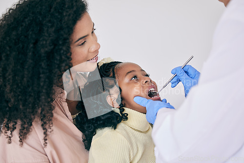 Image of Children, mother and a girl at the dentist for oral hygiene or a checkup to search for a cavity or gum disease. Kids, dental or healthcare with a female child and mother at the orthodontist