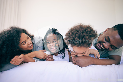 Image of Laugh, relax and morning with black family in bedroom for wake up, bonding and affectionate. Weekend, smile and care with parents and children at home for playful, funny and free time together