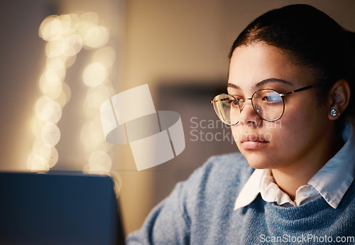 Image of Business, student or concentration laptop in night office on financial software, investment data or mockup growth analytics. Serious, reading and working late woman on technology for finance learning