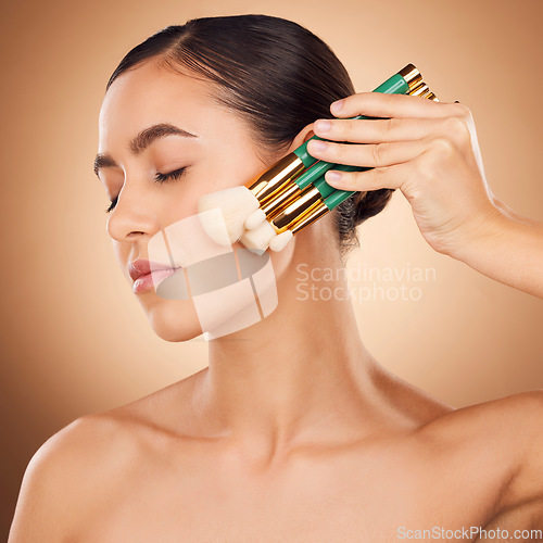 Image of Beauty, cosmetics and makeup, woman with brushes on face, aesthetic brown background and studio profile. Skincare, facial transformation and luxury cosmetic product for glowing skin on elegant model.