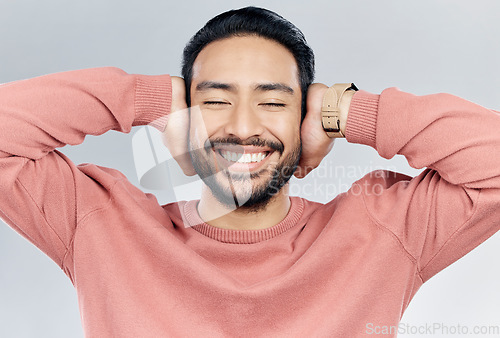 Image of Face, happy and silence with a man in studio on a gray background to cover his ears while enjoying quiet. Noise, smile and relax with a handsome young male blocking sounds with his hands for peace