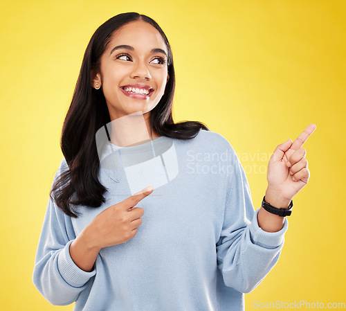 Image of Yellow background, point and face of woman with smile for advertising, promotion and announcement. Mockup space, studio and isolated happy girl with hand gesture for information, discount or news