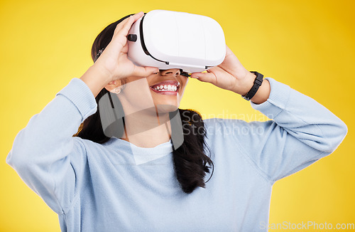 Image of Woman with VR goggles, smile and experience in metaverse, digital world and futuristic on yellow studio background. Virtual reality, technology and UX, happiness and cyber space with gaming