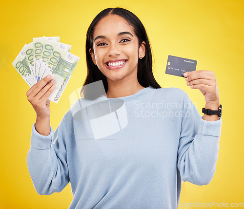 Image of Woman, portrait smile and credit card with money for ecommerce, shopping or banking against a yellow studio background. Happy female shopper smiling and holding cash and debit from bank withdrawal