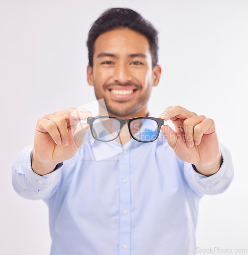 Image of Glasses, happy man portrait and studio with a optometrist showing an eye wear product. Smile, happiness and frame choice sale of a male model with lens check and optometry with blurred background