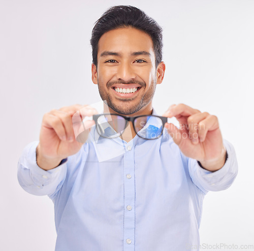 Image of Glasses, vision portrait and man happy in studio for eye care, lens or frame isolated on a white background. Smile of asian male model show optometry eyewear brand in hands to check eyesight or focus