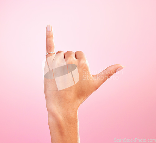 Image of Woman hand, shaka and studio with a icon, emoji and hang ten surfing sign. Isolated, pink background and female hands showing winner, surf and motivation signal with mockup and winning gesture