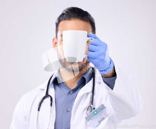 Image of Hand, coffee and break with doctor man in studio on a gray background for a drink to start his morning. Medical, healthcare and beverage with a medicine professional holding a cup or mug for tea