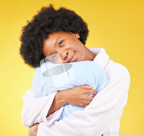 Image of Sleepy, tired and a black woman hugging a pillow on a yellow background in studio at bed time. Relax, wake up and comfort with an attractive young female holding a cushion in the morning after rest