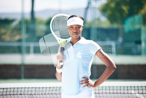 Image of Tennis, portrait and serious black woman on court ready for match, game or competition. Fitness, sports racket and young, proud or confident female athlete from Nigeria preparing for training workout