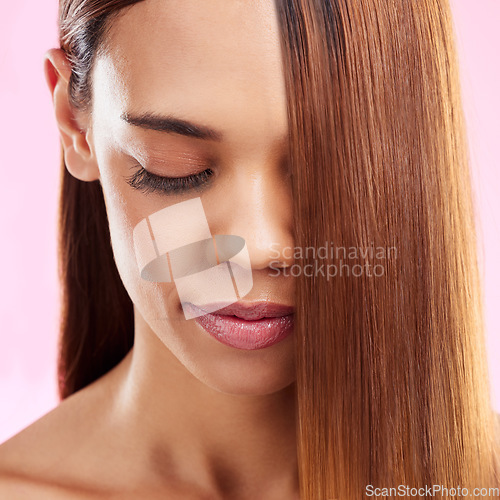 Image of Beauty, hair and face closeup of black woman isolated in studio with pink background for salon advertising. Haircare, straightener and Brazilian hairstyle on model for luxury growth product promotion