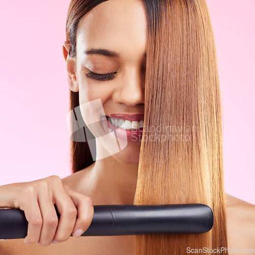 Image of Happy, woman and hair straightener for beauty, salon treatment and girl on studio background. Female, lady and tool for cosmetics, texture and volume with grooming, shine and glow with smile and spa