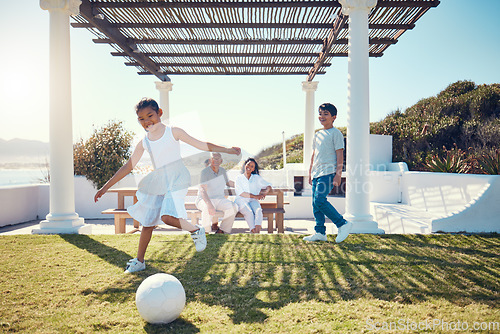 Image of Family, vacation and children playing soccer on a lawn in a holiday house and girl kick a ball having fun outdoors. Happy, excited and grandparents watch kids on the grass to play football