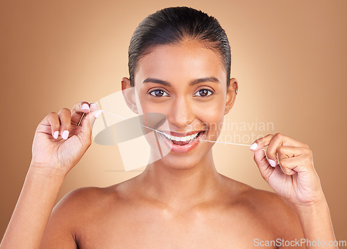 Image of Floss, studio and portrait of a woman with healthcare, cleaning and dental health. Isolated, brown background and young female model with happiness from clean teeth and mouth wellness with a smile